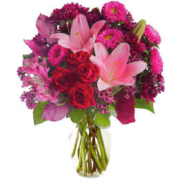 Pink lilies and red roses in a clear glass vase