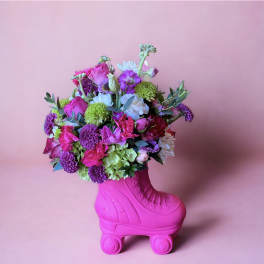 Bright mixed bouquet in a pink roller skate vase