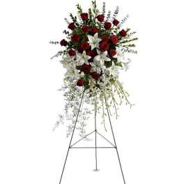 Standing floral spray with red roses and white lilies on a metal easel