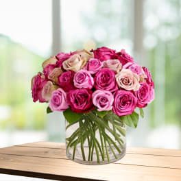 Bouquet of pink and blush roses in a clear glass vase