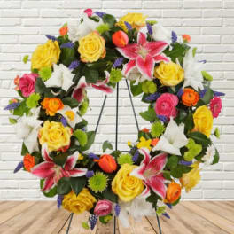Colorful floral wreath with roses and lilies on a metal stand
