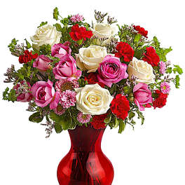 Mixed pink, white, and red roses in a red glass vase