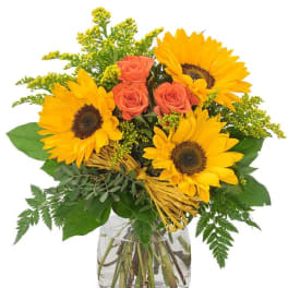 Sunflowers and coral roses in a clear glass vase