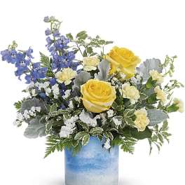 Yellow roses and blue flowers in a blue glass vase