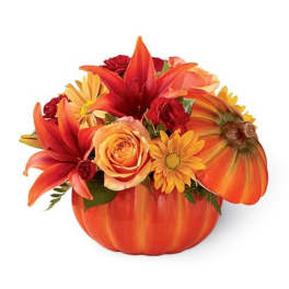 Orange floral arrangement in a pumpkin-shaped container