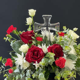 Red and white floral arrangement with a clear glass cross centerpiece