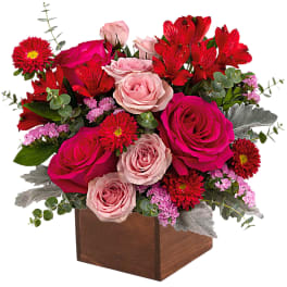 Pink and red rose arrangement in a wooden box