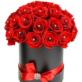Red roses arranged in a black hatbox with a red ribbon