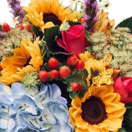 Mixed bouquet with sunflowers, roses, and blue hydrangeas