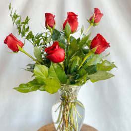 Red roses arranged in a clear glass vase