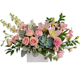Pink roses and lilies arranged in a white rectangular vase