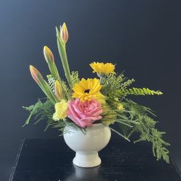 Pink rose and yellow daisy arrangement in a white vase
