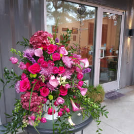 Large pink floral arrangement with roses, hydrangea, and calla lilies