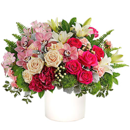 Mixed bouquet of pink and white flowers in a white vase