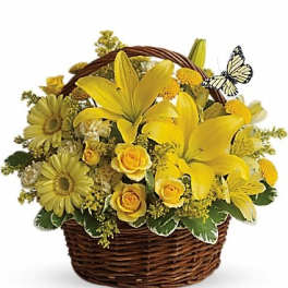 Yellow floral basket arrangement with lilies, roses, and daisies