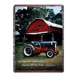A woven blanket with a farm scene and a tractor