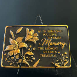 Decorative plaque with gold lilies and a memorial quote