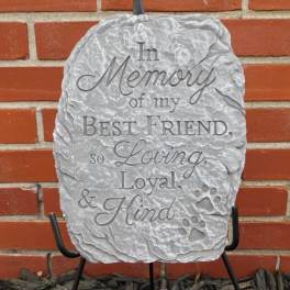 Gray memorial stone with engraved tribute text and paw prints