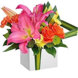 Pink lilies and orange roses in a white cube vase