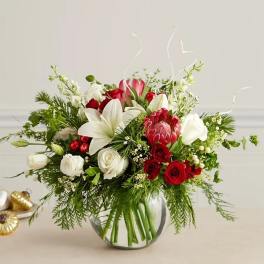 Red and white floral arrangement in a round glass vase