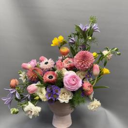 Mixed bouquet in a pink vase with pink, purple, white, and yellow flowers
