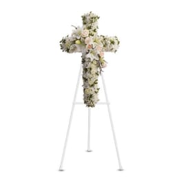White floral cross arrangement on a stand