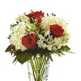Red roses and white hydrangeas in a clear glass vase