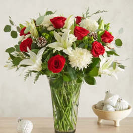Red roses and white lilies in a clear glass vase