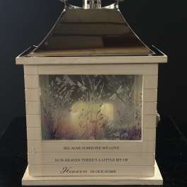 Decorative memorial lantern with a candle inside and floral artwork