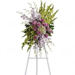 Tall floral spray on a metal easel with purple flowers and green accents