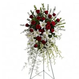 Standing floral spray with red roses and white lilies on an easel
