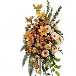 Standing floral spray with yellow and peach flowers on a metal easel