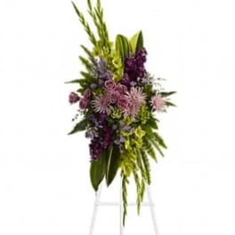 Tall floral spray with purple and pink blooms on a white stand