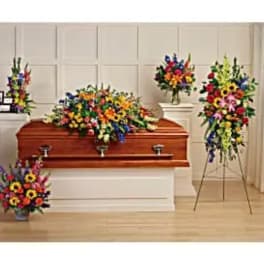 Colorful funeral floral arrangements around a wooden casket