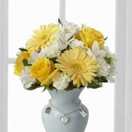 Yellow and white flowers arranged in a pale blue vase
