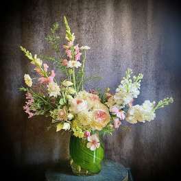 Tall mixed floral arrangement in a glass vase with pink and white blooms