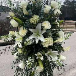 Large white floral standing spray with lilies and roses