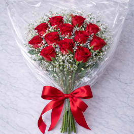 Bouquet of red roses wrapped in clear plastic with a red ribbon