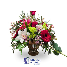 Mixed bouquet in a glass vase with red, pink, white, and green flowers