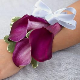 Purple calla lily wrist corsage with a white ribbon