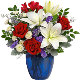 Red roses and white lilies in a blue glass vase
