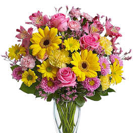 Bouquet of pink and yellow flowers in a clear glass vase