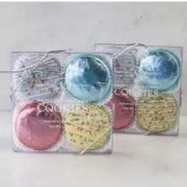 Two clear gift boxes of assorted frosted cookies in pastel colors tied with silver string