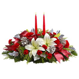 Holiday centerpiece with white lilies, red carnations, and two red candles