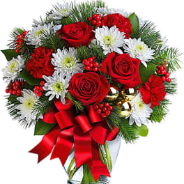 Red roses and white daisies in a glass vase with a red ribbon