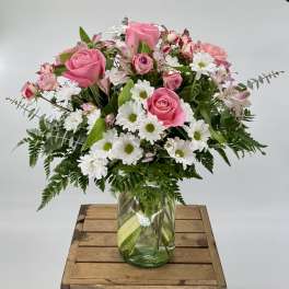 Pink roses and white daisies in a glass vase