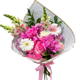 Pink and white mixed bouquet wrapped in decorative paper with a pink ribbon