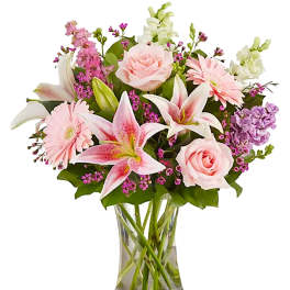 Pink and white mixed flowers arranged in a clear glass vase