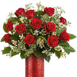Red roses arranged in a red vase with white filler flowers