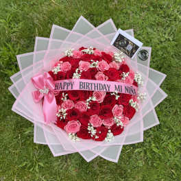 Pink and red rose bouquet with a birthday ribbon and bow